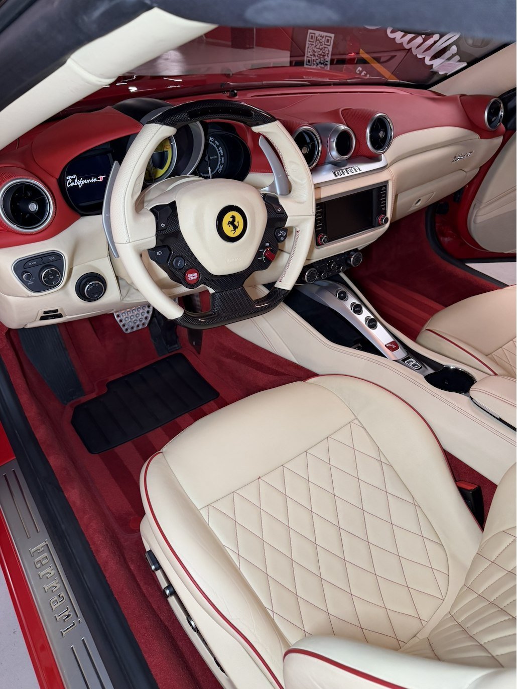 Volant, tableau de bord siglé California T et sellerie cuir crème et rouge d'une Ferrari California T